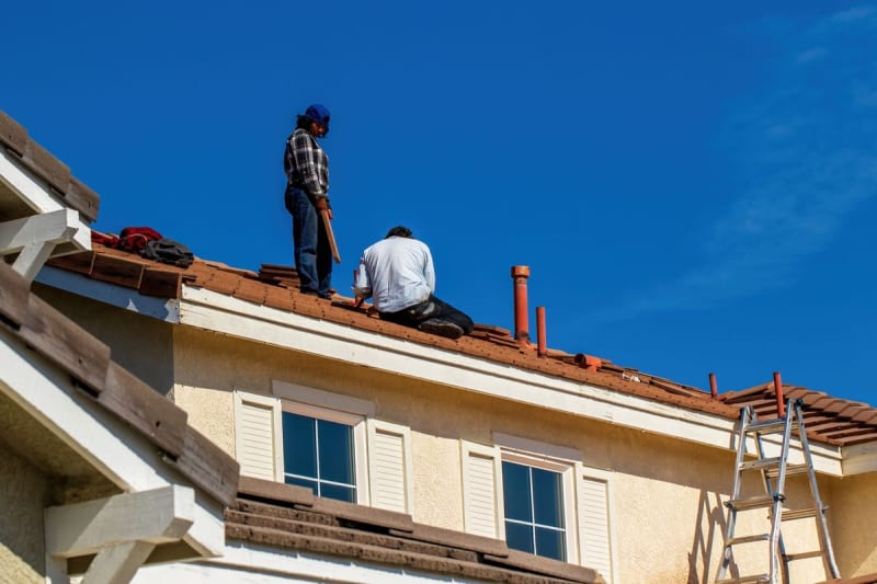 Roofers at work on a pitched tiled roof in Mansfield