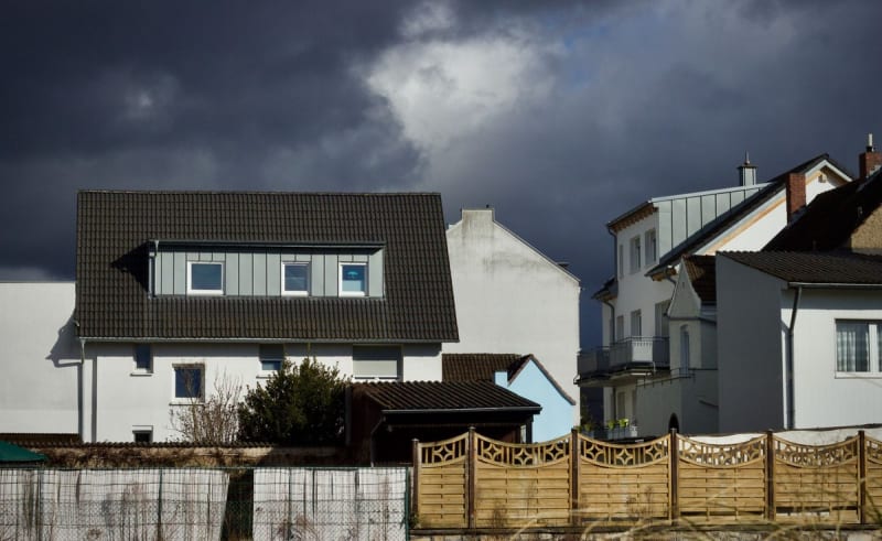 Dark storm clouds gathering over rooftops of houses in the Mansfield area