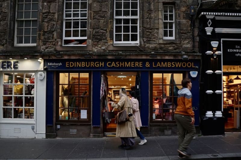 Retail units on a UK high street with flat roofs over the shopfronts