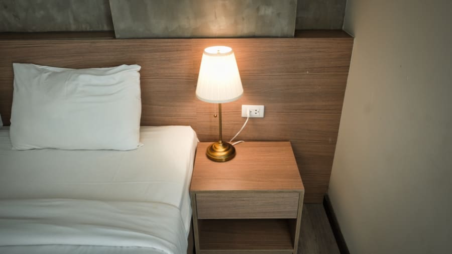 Guest room with bedside power, charging and controllable lighting
