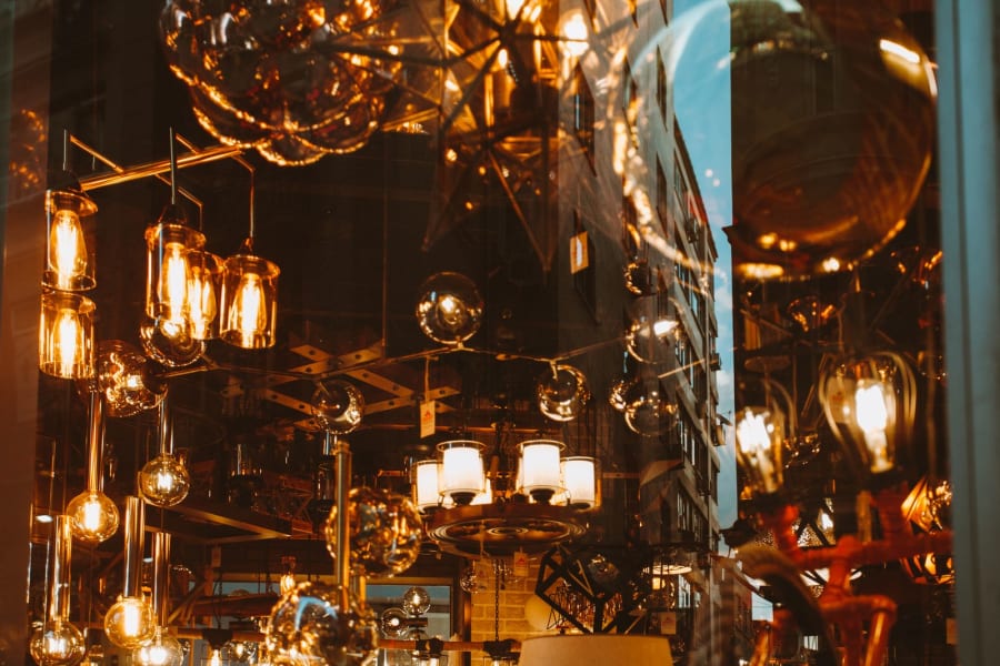 Warm amber-lit hanging glass lights and reflective fixtures in a dark, decorative interior.