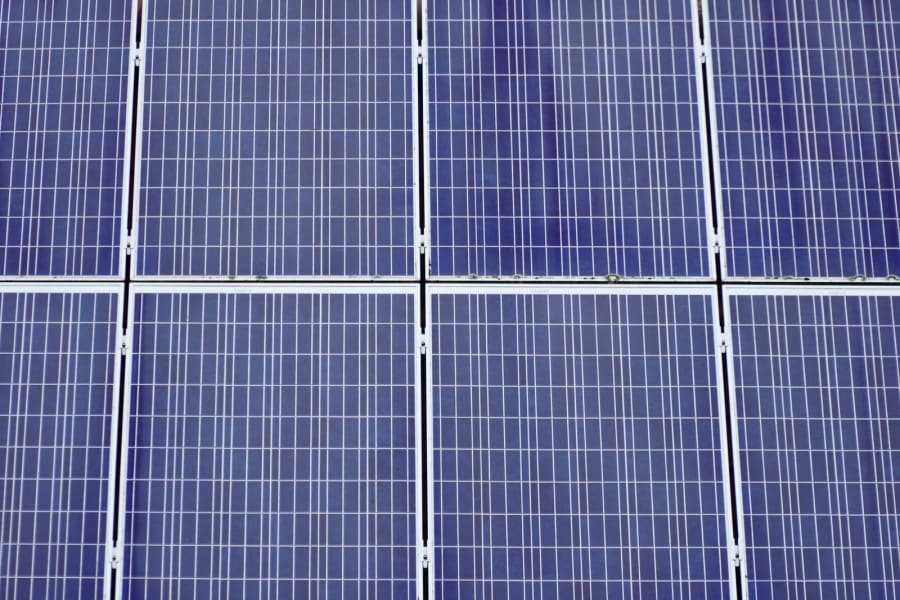Rows of blue solar panels with white grid lines, seen from above.
