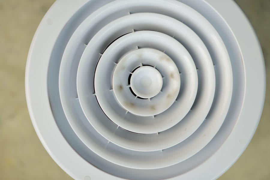 White concentric circular vent or speaker grille with a small central hub, viewed from above