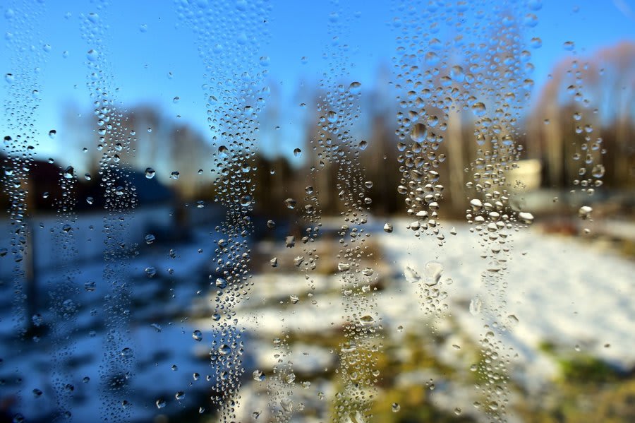 Cold draughty window interior showing condensation in winter
