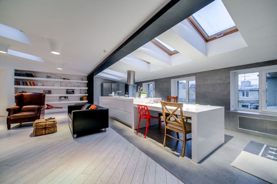 Open plan loft conversion in Cornwall with an exposed staircase and full-height glazing