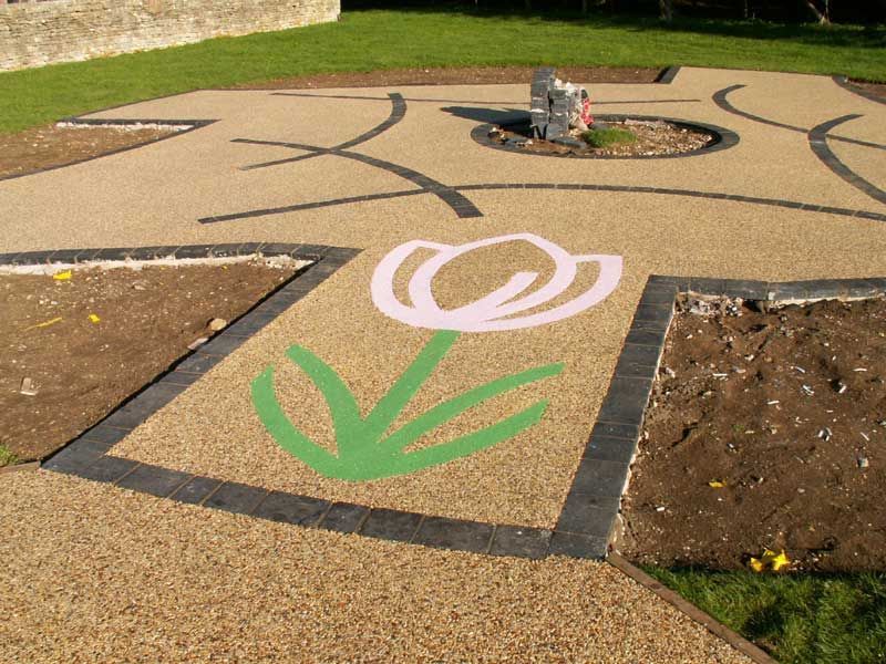 Commercial resin driveway with a green and pink flower pattern on it