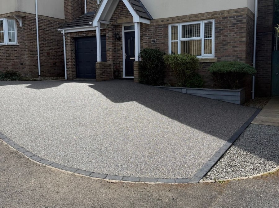 Grey resin driveway with a block paving diamond pattern on it