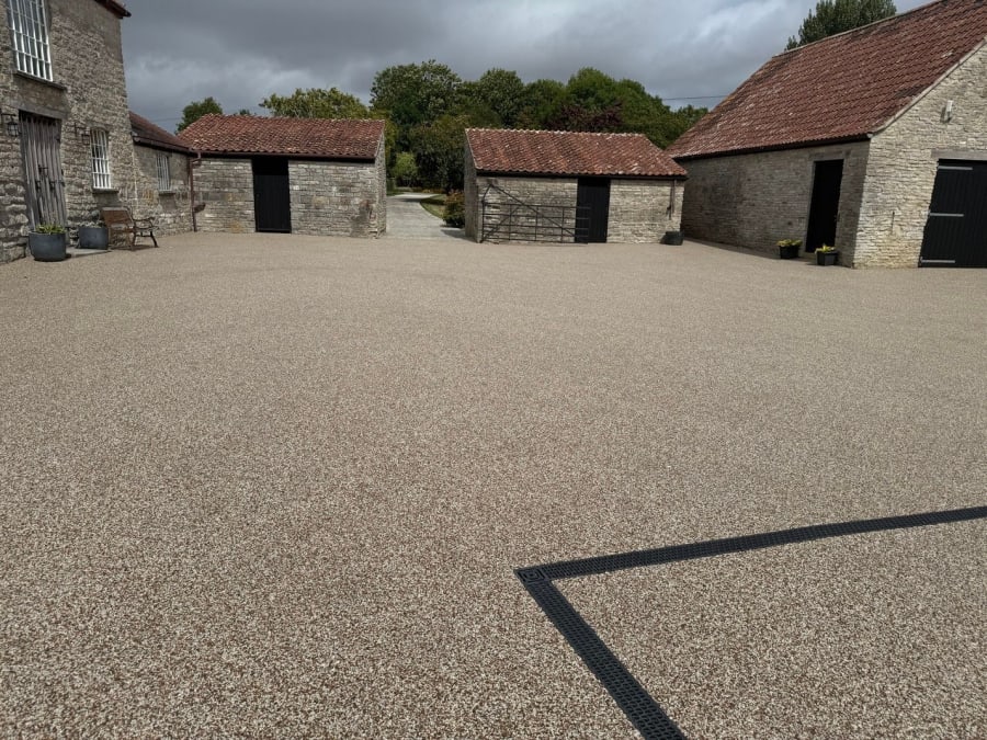Light resin driveway with two wooden gates open