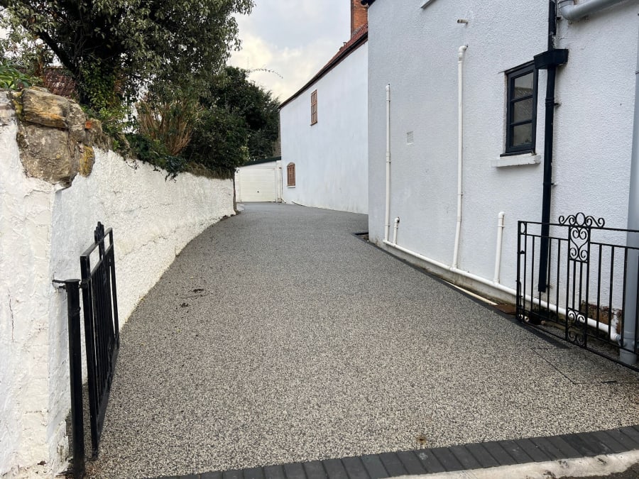A gravel driveway leading to a white building