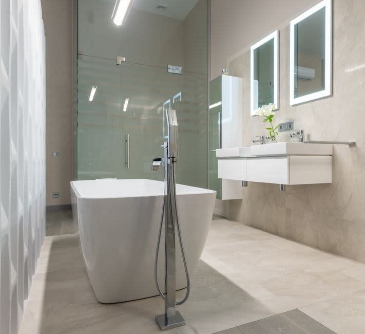 Minimal bathroom with a freestanding bath and wall-hung basin unit in an Exeter home