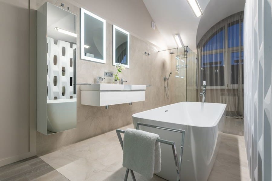 Freestanding bath positioned beneath an arched window in an Exeter bathroom