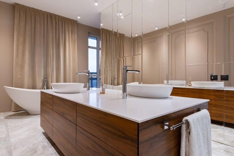 Bathroom design in Exeter featuring a walnut island vanity with twin counter-top basins