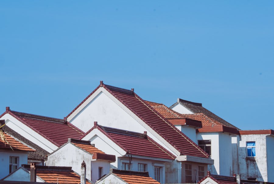 Tiled roofs on Melbourne homes against a blue sky
