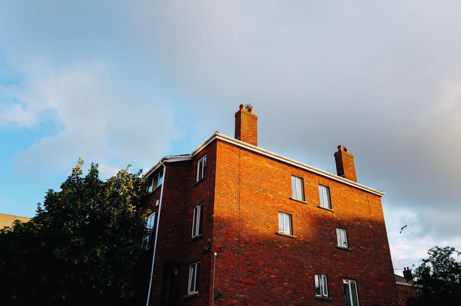 A brick house with a pitched roof and chimney stack
