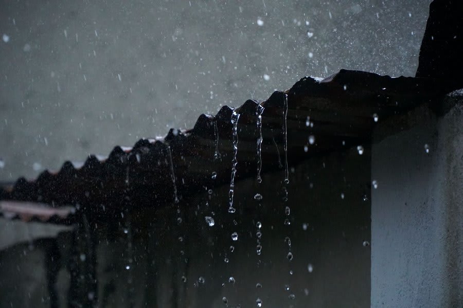 Rain dripping from the edge of a roof