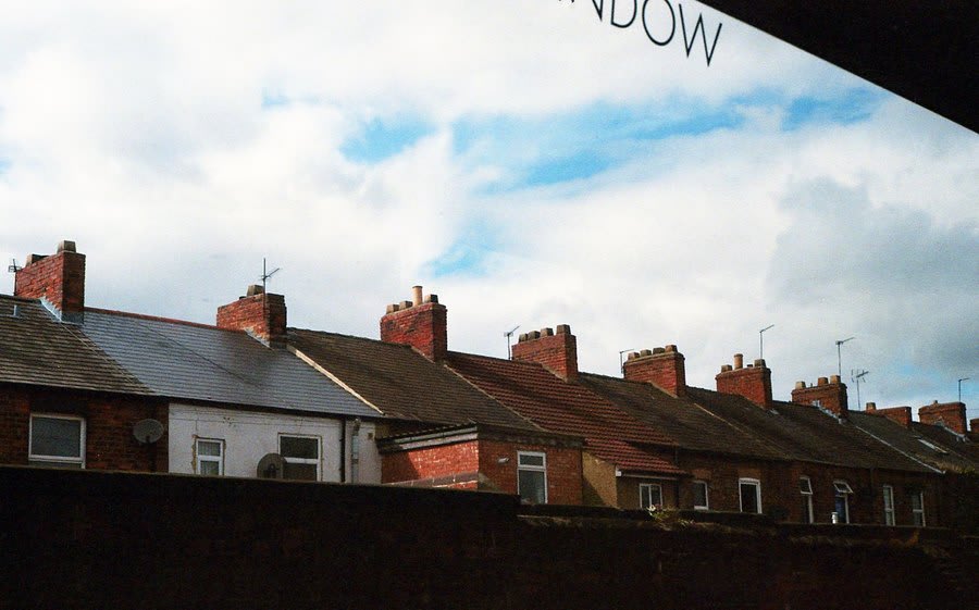 Chimney stacks and rooflines seen against the sky, the lines checked for movement