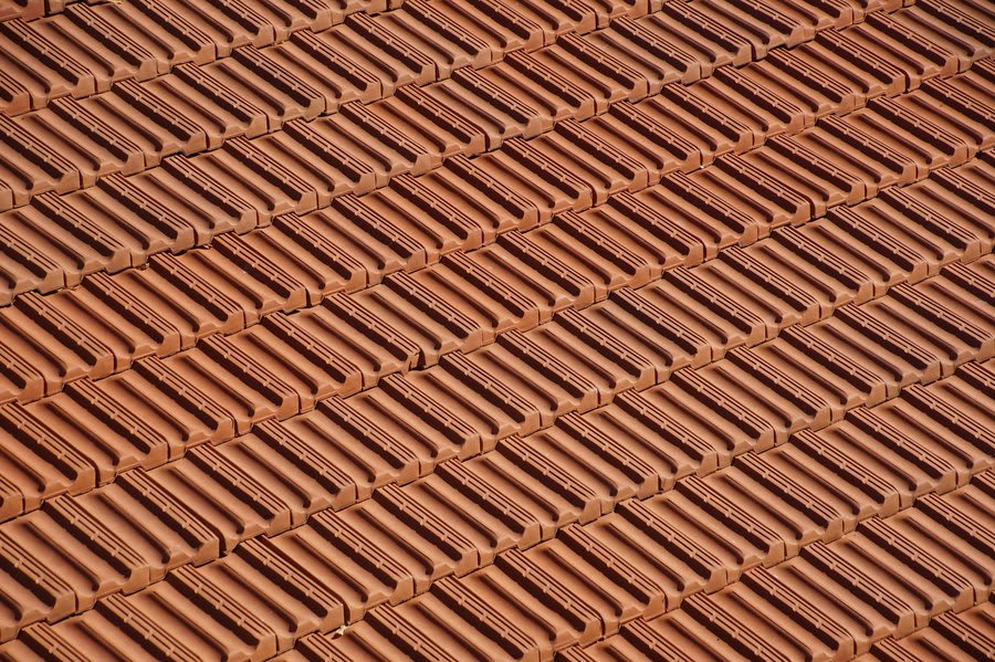 Close view of weathered clay roof tiles showing surface wear