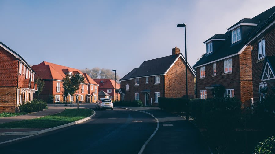 Street of newer estate houses with modern tiled and flat roofed elements