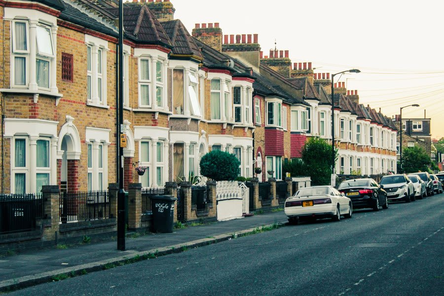 Terraced street of brick houses with parked cars after wet weather