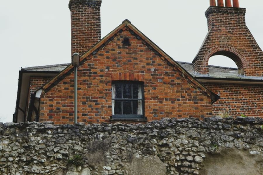 A brick house with chimney and pitched roof