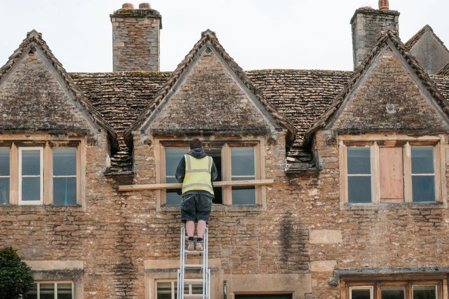 Construction worker removing an old window during home renovation