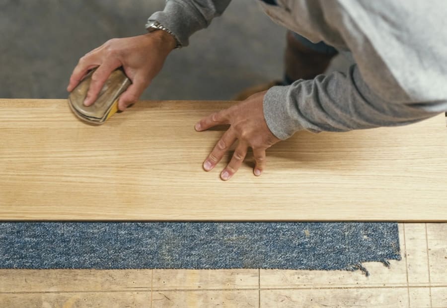 Hand finishing a timber panel in the workshop before it is delivered