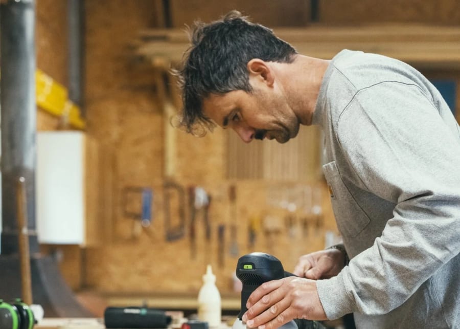 Joiner sanding a timber component at the bench before finishing
