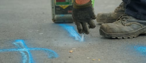 Heffernan Utilities working marking the pavement with blue spraypaint