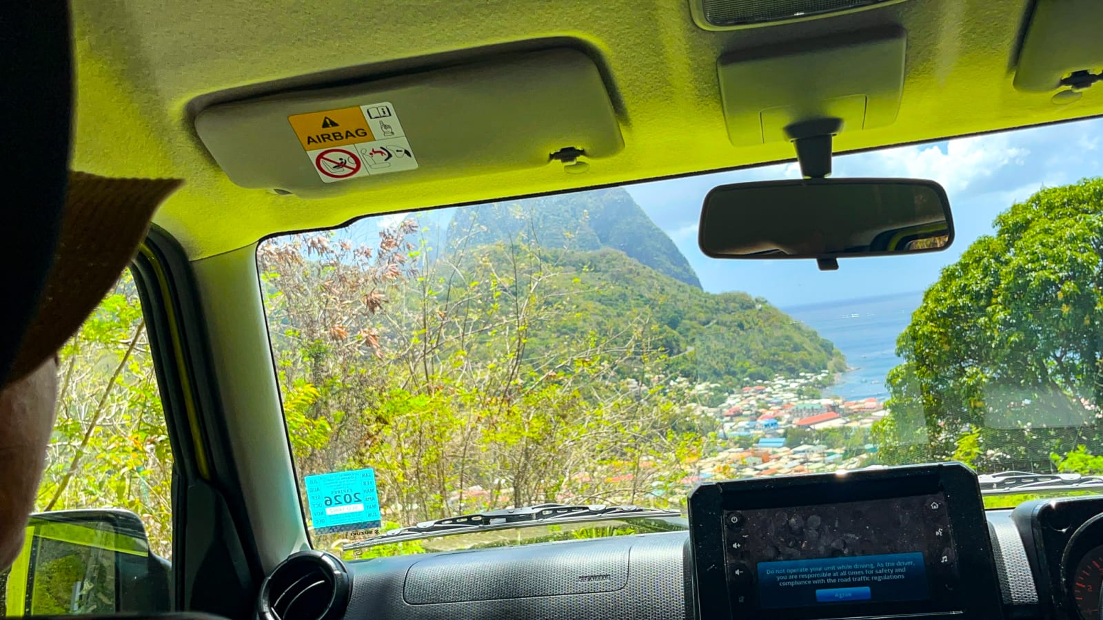 The view driving down toward Soufrière, with the coast and hills ahead
