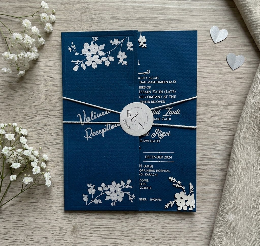 A frosted acrylic wedding card with white text and floral borders