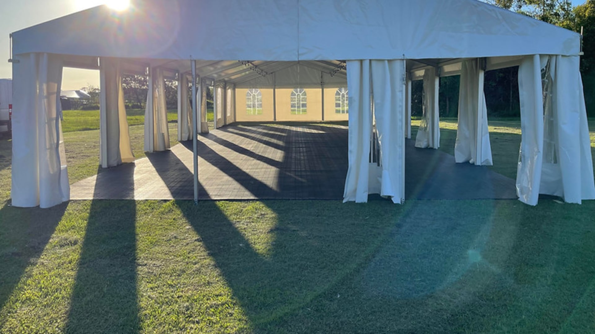 Party hire Brisbane — clearspan marquee with festoon lighting and dance floor installed