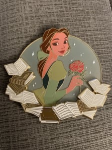 Stylized Belle in green dress with rose, on-pin books at bottom image