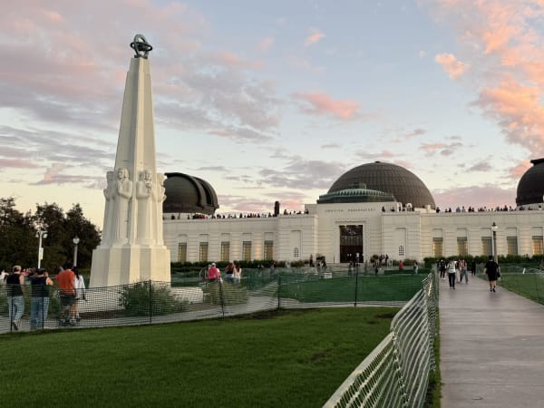 Art Deco building with dome roofs and tall monument at Griffith Observatory, Los Angeles.