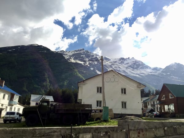 Mountain village with Soviet-era buildings and military truck, Mount Elbrus Expedition