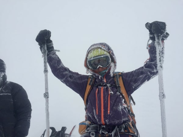 Mountaineer in winter gear raising ice-covered poles, Mount Elbrus Expedition