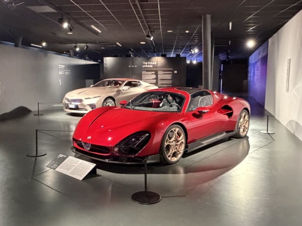 Automotive museum interior in Turin with red sports car and silver concept sedan on display