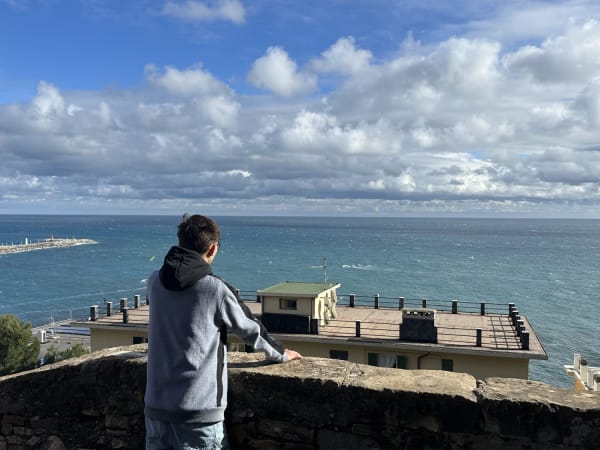 Person looking at the ocean from a stone wall in Imperia, Italy