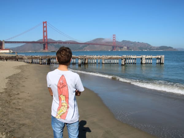 Person on sandy beach near pier and bridge at Horseshoe Bay & Golden Gate View (Sausalito Area)