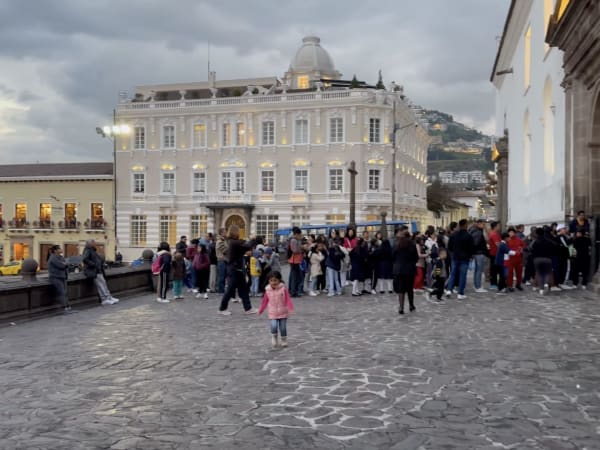 Main square in Quito old town with historic buildings and people gathering