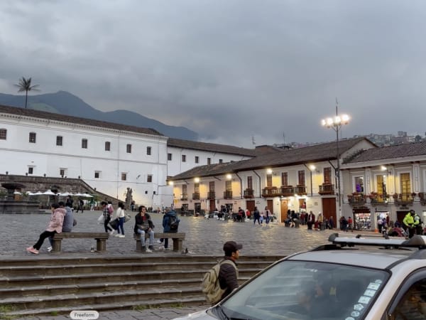 Public square in Quito with mountains in the background and people relaxing