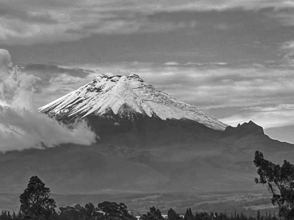 Snow-capped Cotopaxi volcano rising above clouds in Ecuador