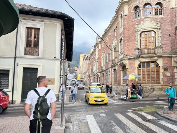 Corner of a colonial building with rounded windows and street traffic in La Candelaria, Bogotá, Colombia