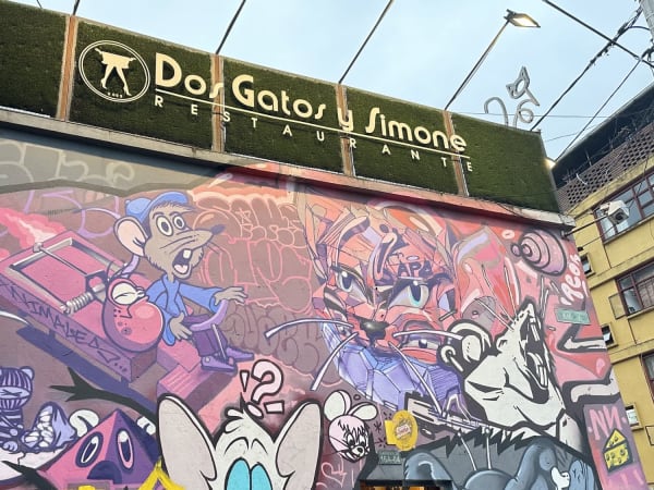 Colorful graffiti mural with cartoon characters on a city wall in Bogotá
