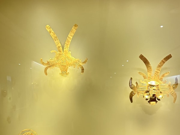 Small golden figurines resembling insects displayed in Museo del Oro
