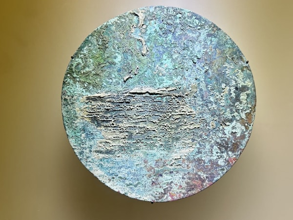 Ancient metal disc with aged surface displayed in Museo del Oro