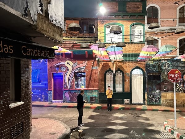 Narrow street at night with colorful umbrellas and lights in La Candelaria Bogotá