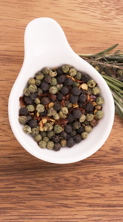 A woman watering bean plants in her garden