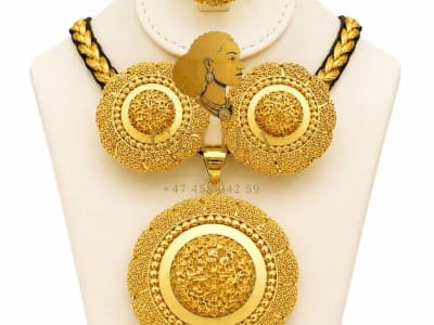 A beautifully handcrafted 21K gold necklace set featuring a statement pendant, matching earrings, and ring. Designed with intricate detailing and a radiant finish, this elegant collection is perfect for weddings, celebrations, and everyday luxury.