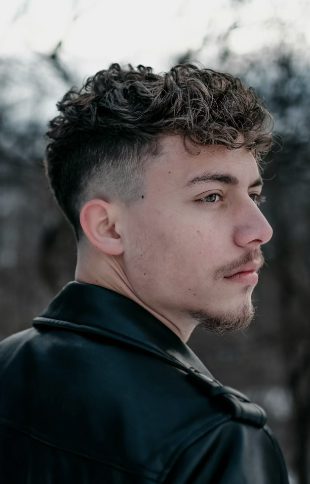 Men's textured curl with fade, side profile