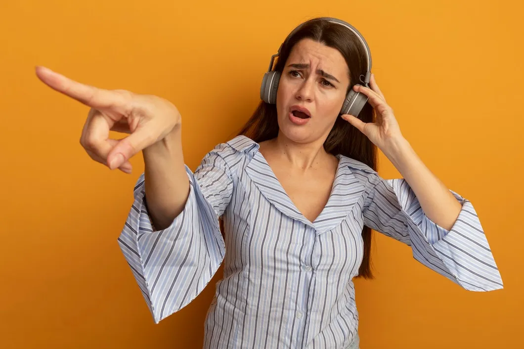 Person wearing headphones and pointing, demonstrating noise cancellation approaches.